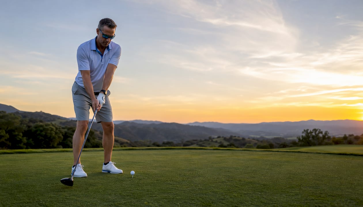 Male golfer wearing polarized sunglasses on course