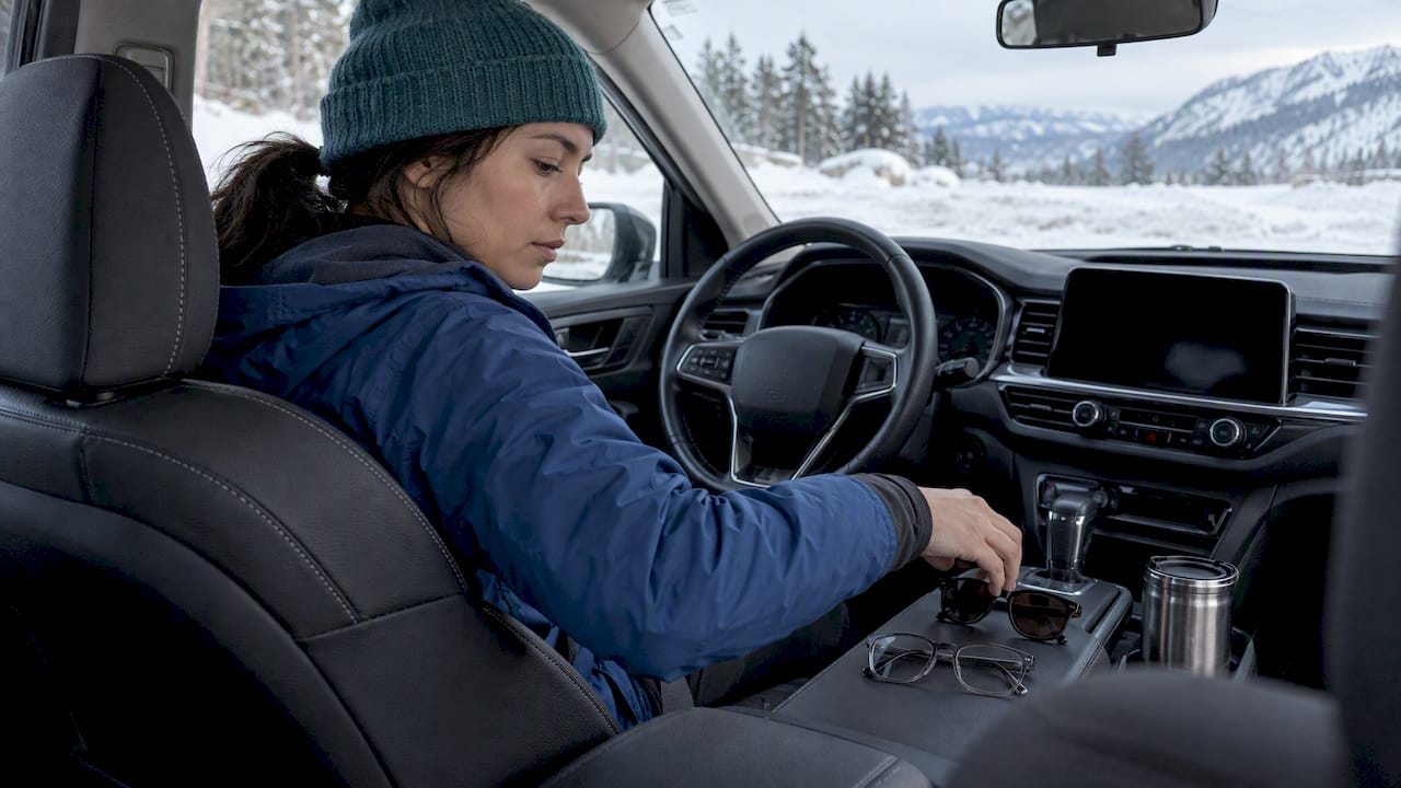 Driver choosing eyewear beside a snowy road