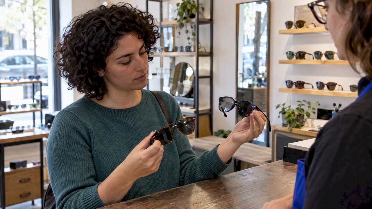 Customer comparing two pairs of sunglasses