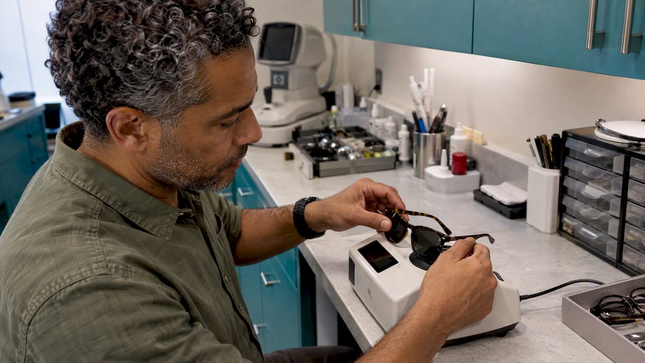 Optician testing sunglasses with a UV meter